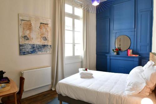 une chambre bleue avec un lit et une fenêtre dans l'établissement Les Chambres du Cloître, la Beurrière, à Limoges