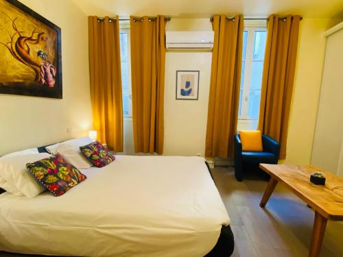 une chambre avec un lit, une table et une chaise dans l'établissement L'Escale Marseillaise, à Marseille