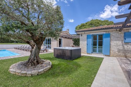 un árbol en el patio de una casa en Villa Mali Vareski with Pool - Happy Rentals, en Mali Vareški