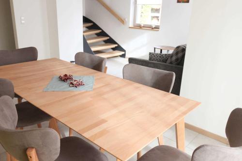 Un comedor con mesa y sillas de madera. en Villa Liselotte, en Fürstenberg-Havel