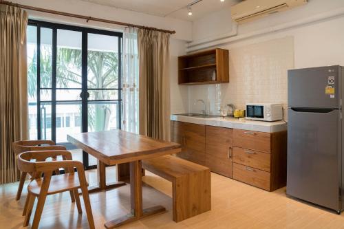 a kitchen with a wooden table and a refrigerator at Chiang Mai Mansion 2 in Chiang Mai