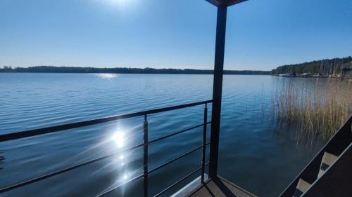 a boat on a large body of water at Houseboat SeeSea Mazury - Domek na wodzie Bogaczewo k Giżycka in Bogaczewo