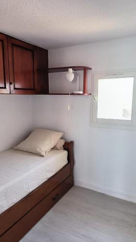 une petite chambre avec un lit et une fenêtre dans l'établissement Douce parenthese a St Cyprien vue Lagune, à Saint Cyprien Plage