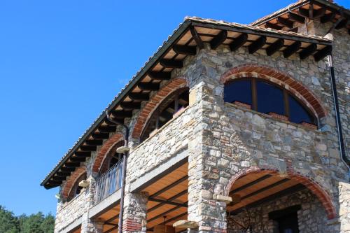 a stone house with an arched window at Mas merolla casa para descanso familiar in Gombreny