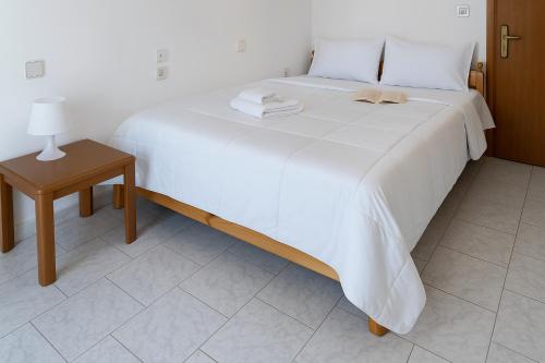a white bed with two towels on top of it at Mak Luxury Rooms in Parga