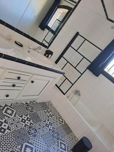 La salle de bains est pourvue d'un lavabo, d'une baignoire et de carrelage. dans l'établissement Vue imprenable sur les oliviers!, à Langlade