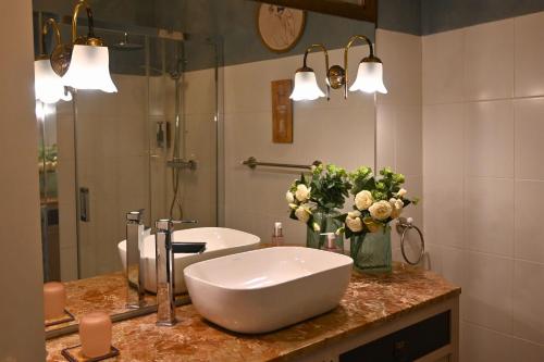 a bathroom with a sink and a vase of flowers on a counter at La Casa de los Coy in Mula