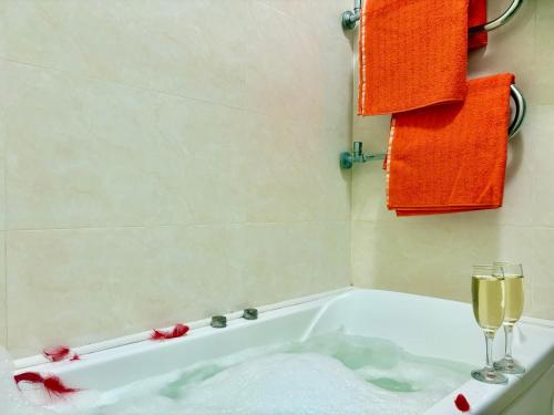 a bathroom with a bath tub with a glass of wine at Апартаменты возле метро НАУЧНАЯ in Kharkiv