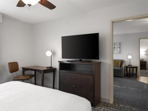 a hotel room with a bed and a flat screen tv at Homewood Suites by Hilton Akron/Fairlawn in Akron