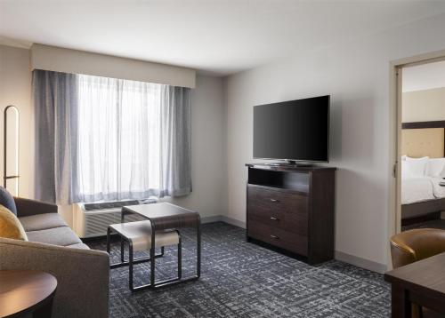 a hotel room with a bed and a flat screen tv at Homewood Suites by Hilton Akron/Fairlawn in Akron