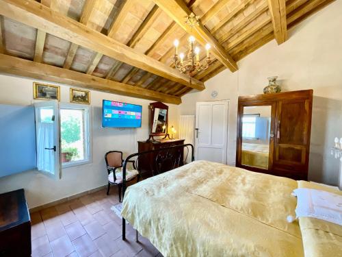 a bedroom with a large bed and a tv at Rustico con Jacuzzi privata BBQ e 3 camere in Montegridolfo