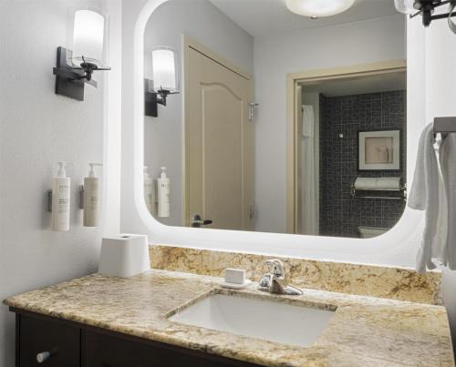 a bathroom with a sink and a large mirror at Homewood Suites by Hilton Akron/Fairlawn in Akron