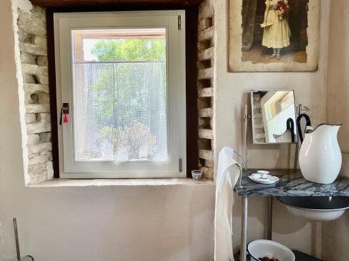a bathroom with a window and a table with a sink at Rustico con Jacuzzi privata BBQ e 3 camere in Montegridolfo