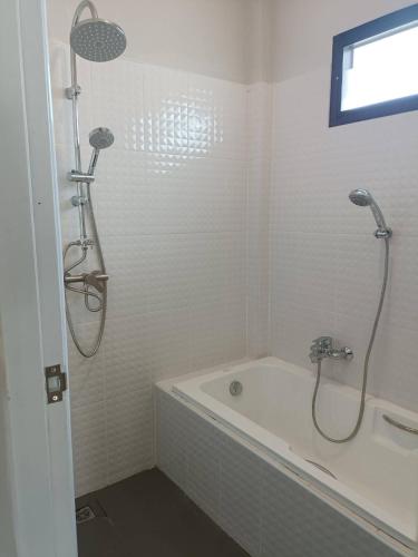 a white bathroom with a tub and a shower at เชียงรายฟิวชั่น in Ban Pa Faek