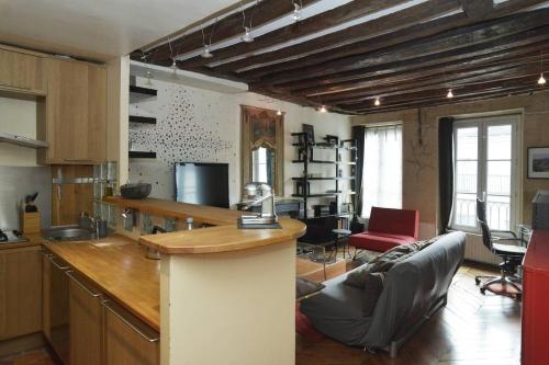 Il comprend une cuisine et un salon avec un bar et un canapé. dans l'établissement Le Reflet du Temps, à Paris
