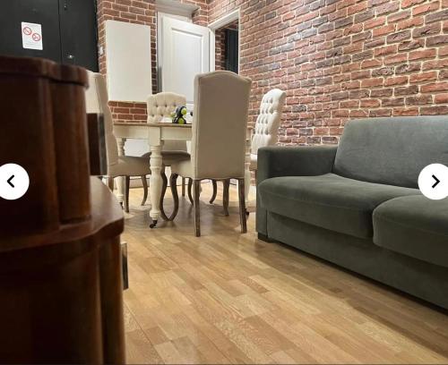 un salon avec un canapé et une table avec des chaises dans l'établissement Sara House, à Paris