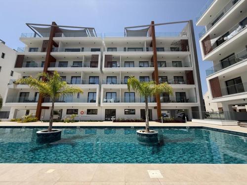 a swimming pool in front of a large apartment building at Chill and Stay-Luxury Studio in Kato Paphos in Paphos City