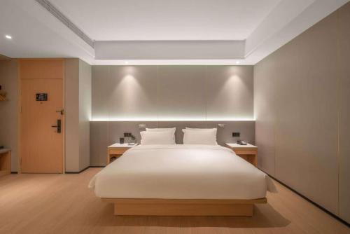 a bedroom with a large white bed with two tables at Atour X Hotel - Taikoo Li Chengdu in Chengdu