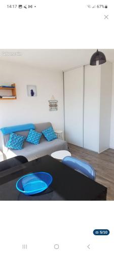 Cette chambre comprend un lit et une table avec des oreillers bleus. dans l'établissement Studio Carnac Plage, à Carnac