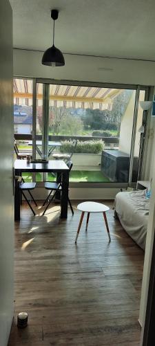 Cette chambre comprend une table, un lit et une fenêtre. dans l'établissement Studio Carnac Plage, à Carnac