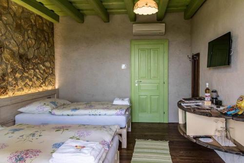 a room with two beds and a green door at Penzión Tokaj Ostrožovič in Veľká Tŕňa