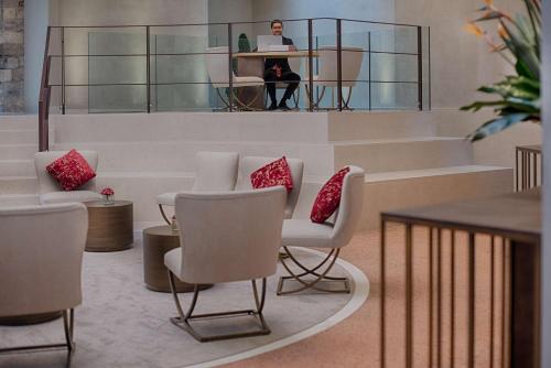 a person sitting at a desk with a laptop in a lobby at NH Collection Palazzo Verona in Verona