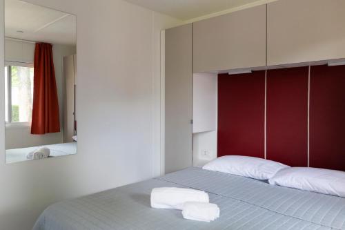 a bedroom with a bed with two towels on it at Camping Rose in Dormelletto