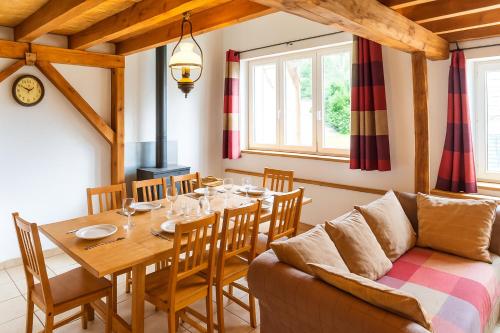 a dining room with a table and a couch at GITE AUTOMNE in Le Soulié