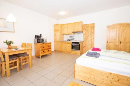 a room with a bed and a table and a kitchen at Ferienwohnung Forsthaus am Brocken, 35 qm, 1 Wohn-Schlafzimmer F1 in Ilsenburg