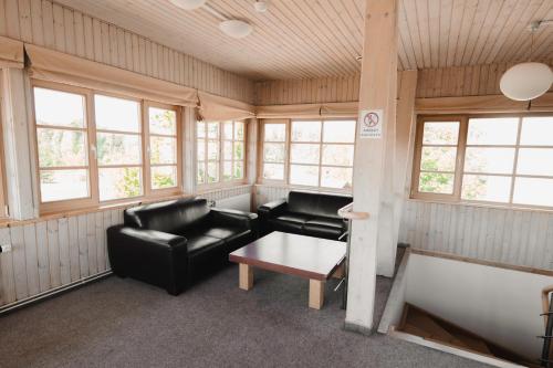 a living room with black leather furniture and windows at Porto Resort in Lilaste