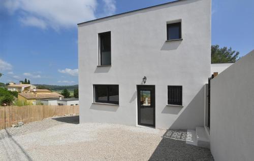 a white house with a door on the side of it at Villa Neuve Proche Nîmes in Calvisson