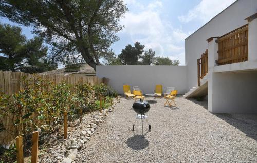 a backyard with chairs and a table and a fence at Villa Neuve Proche Nîmes in Calvisson