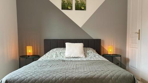 - une chambre avec un lit et deux lampes de chaque côté dans l'établissement Maison avec jacuzzi proche centre, à Saint-Rémy-de-Provence