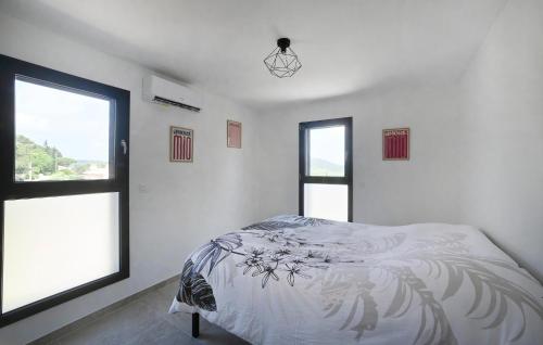 a white bedroom with a bed and two windows at Villa Neuve Proche Nîmes in Calvisson