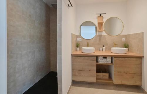a bathroom with two sinks and two mirrors at Villa Neuve Proche Nîmes in Calvisson