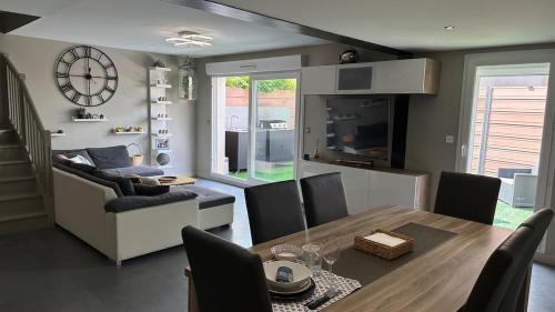 une salle à manger et un salon avec une table et une horloge dans l'établissement Maison avec jacuzzi proche centre, à Saint-Rémy-de-Provence