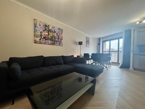 un salon avec un canapé noir et une table dans l'établissement Le Suquetan By SCLS Locations, à Cannes