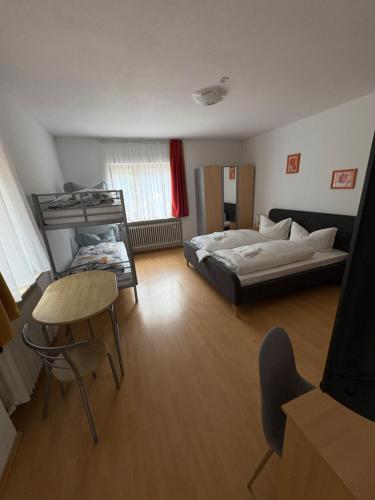 a bedroom with a bed and a table and a chair at Schatzn Hof in Pottenstein