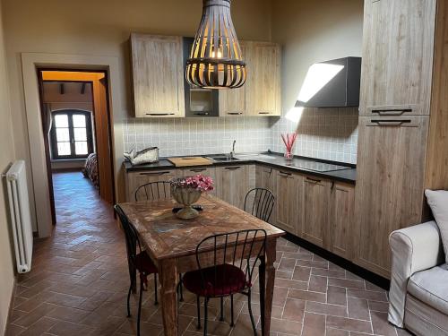 a kitchen with a wooden table with chairs and a dining room at Il Girasole in Chianni
