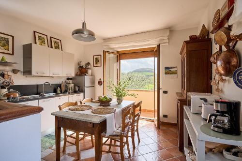a kitchen with a table and chairs and a window at Villa PoliFlora in Monticchiello