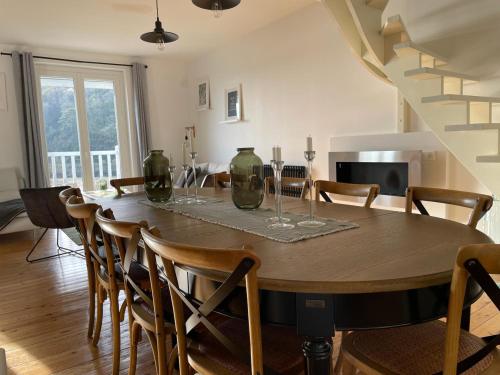 a dining room with a wooden table and chairs at La Maison Du Phare in Plérin