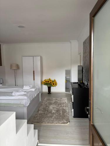 a bedroom with two beds and a vase of flowers at AME Home in Ocna-Mureşului