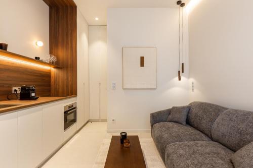 un salon avec un canapé et une cuisine dans l'établissement Le Confidentiel - Quai de Seine, à Paris