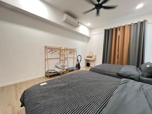 a bedroom with two beds and a ceiling fan at Bay Suite Likas by IGVC in Kota Kinabalu