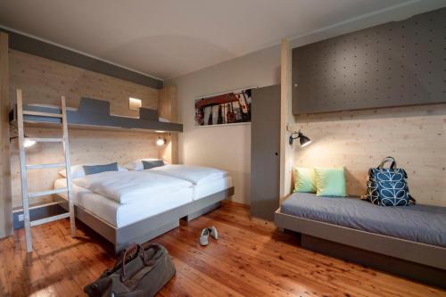 a bedroom with two beds and a bunk bed at JUFA Hotel Maria Lankowitz in Maria Lankowitz