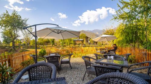 a group of tables and chairs with umbrellas at Dormigo in Bīr