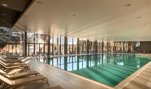 a swimming pool with lounge chairs in a building at Maistra Select Mlini Hotel in Mlini