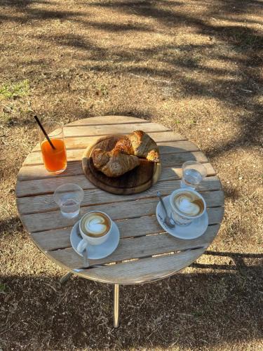 Una mesa de madera con un plato de comida y tazas de café. en MC 1640, en Quasani