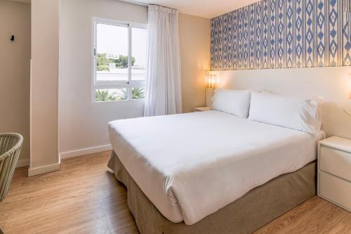a bedroom with a large bed and a window at Exe Portals Nous in Portals Nous