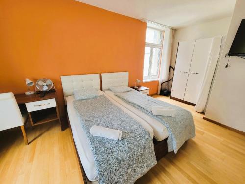 a bedroom with two beds and an orange wall at Renovated Apartment Near Zurich Lake Sees - Self Checkin in Zürich